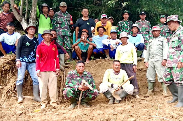 Koramil 1009/Tomo Kodim 0610/Sumedang dipimpin oleh Danramil Kapten Inf Wawan Rahmat Senjaya melaksanakan karya bakti pembuatan saluran air yang terdampak longsor (Dok.Hariansumedang.com / Mat Rahmat IWOI Sumedang )